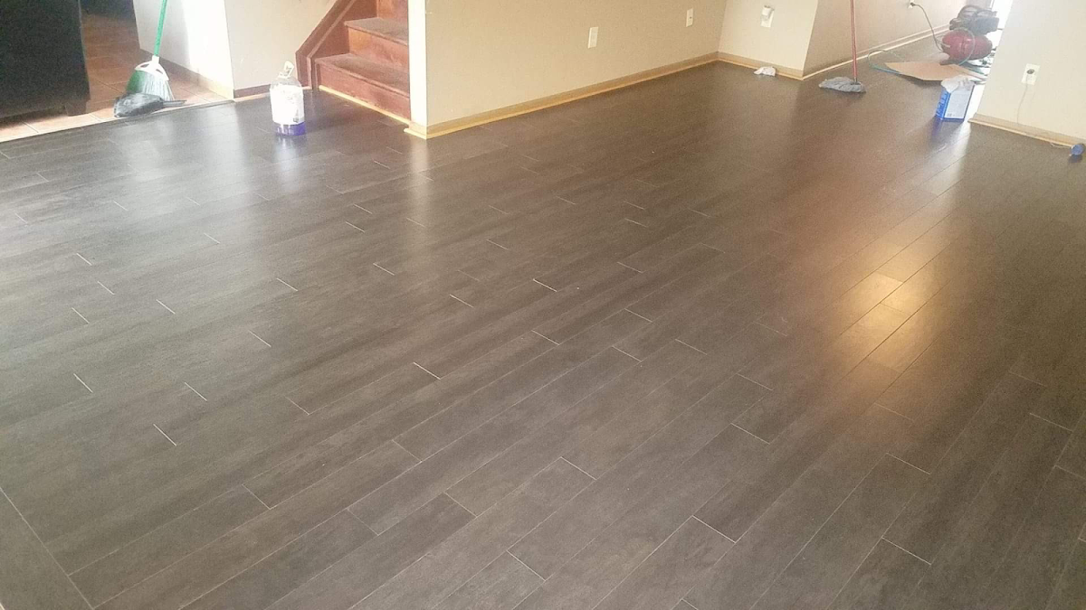Large open basement with newly installed dark espresso wood-look plank flooring