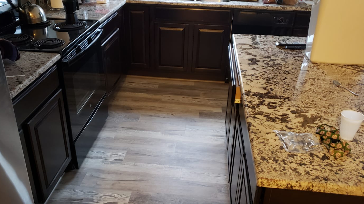 Kitchen with newly installed vinyl plank flooring and granite countertops